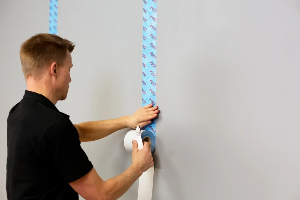 Man monterar RST skarvremsa mot radon på vägg