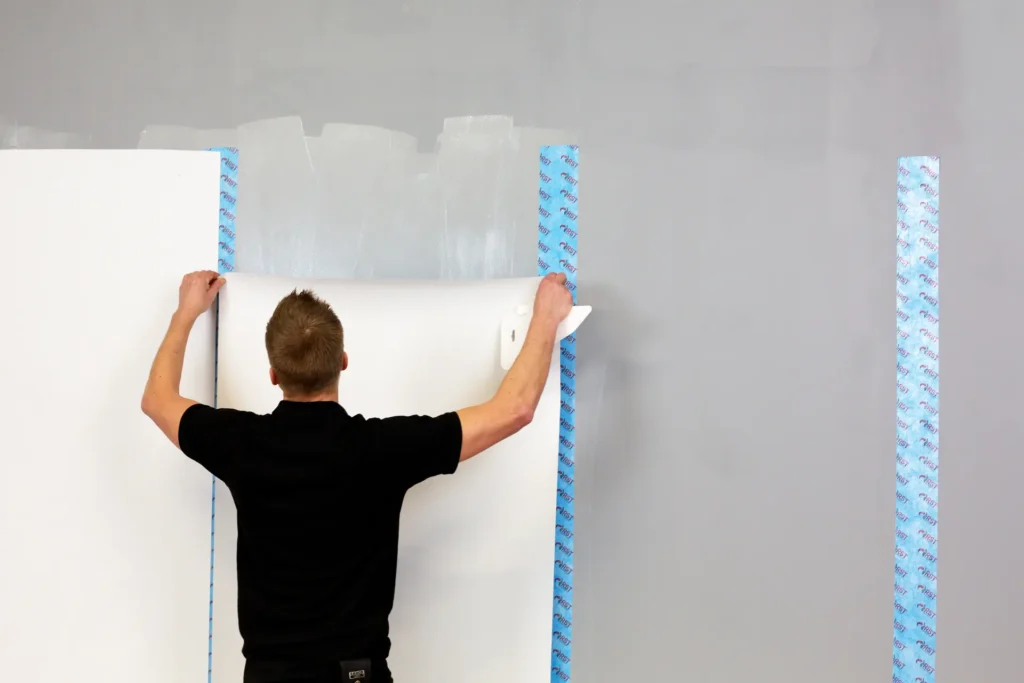 Man monterar RST tapet mot radon på vägg